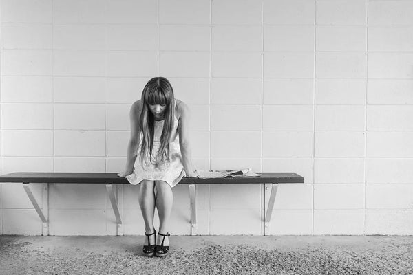 woman sitting on a bench looking downwards