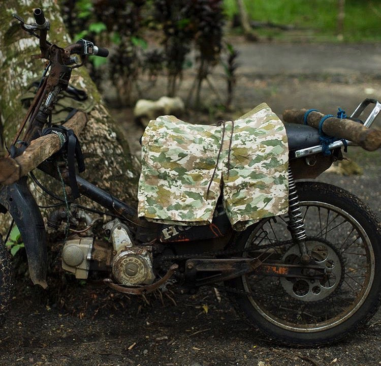 Camo printed boardshorts on top of a old wooden bike in the forest