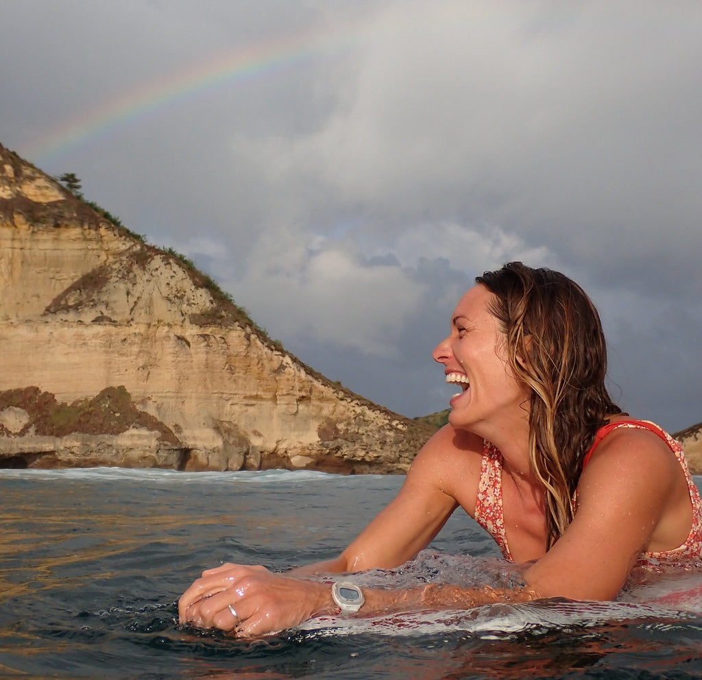 虹を持つ女性サーファー