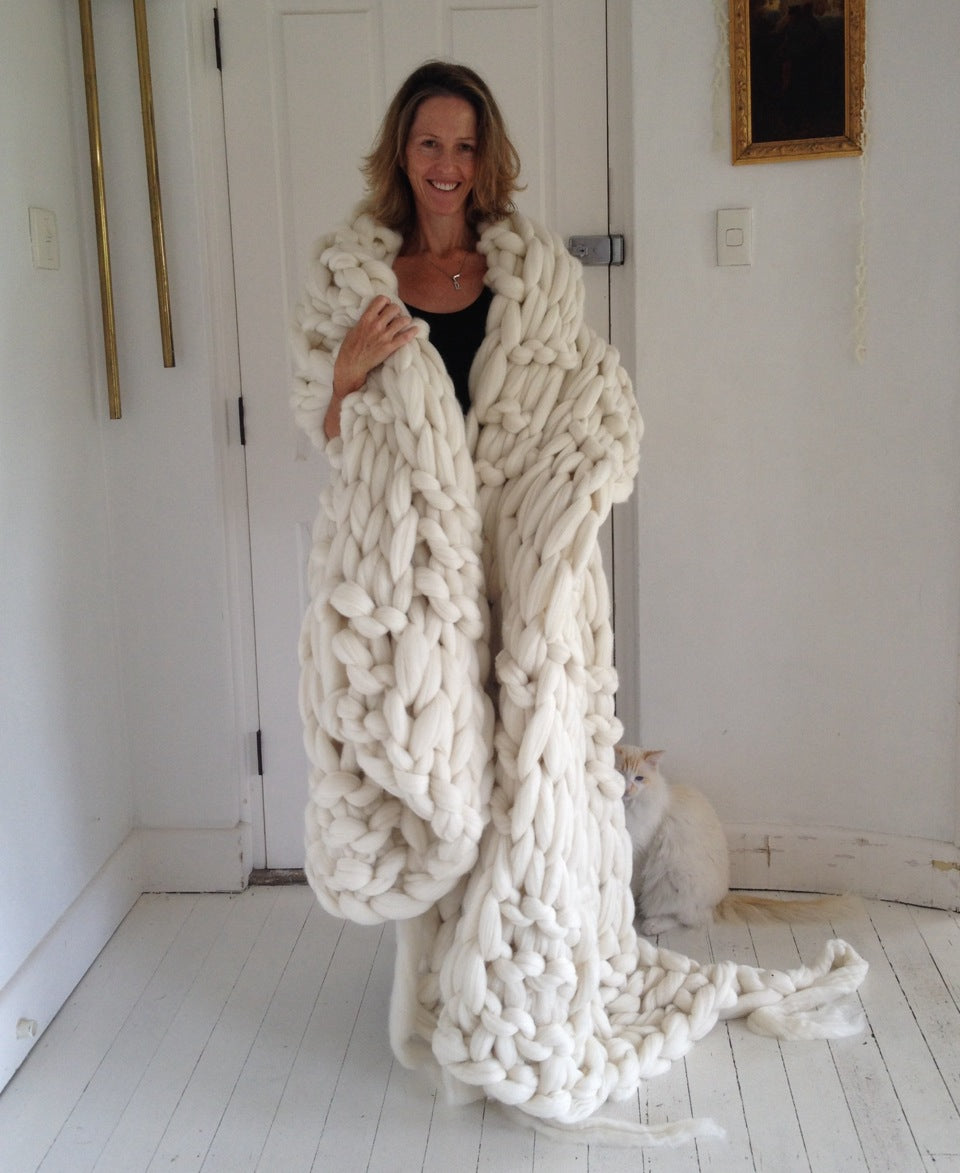 Image of Jacqui Fink wrapped in a blanket knitted with woollen top before it has been felted.