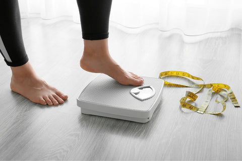 Person gingerly putting a foot on weighing scales