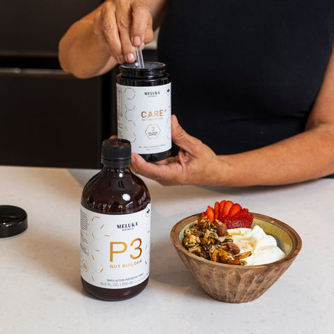 P3 Gut Builder and Care Gut Nutrition powder with a yoghurt bowl on a kitchen benchtop.