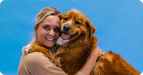 woman and dog smiling and hugging
