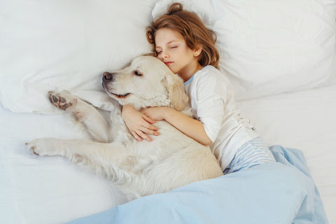 Woman sleeping next to her dog