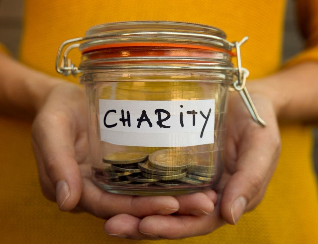 A jar of change that has the word "Charity" written over it