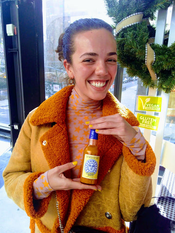 Sunshine Spice Girl Holds a Bottle Of Hattwoods Sauce - 