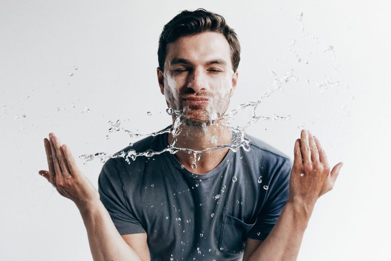 Man splashing water in face