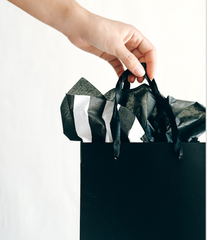 hand holding black shopping bag