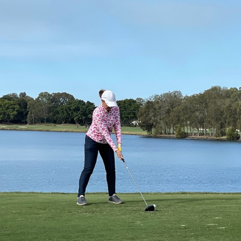 photo of female golfer teeing off