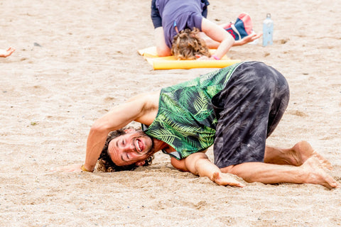 Andy Blake performing yoga on beach