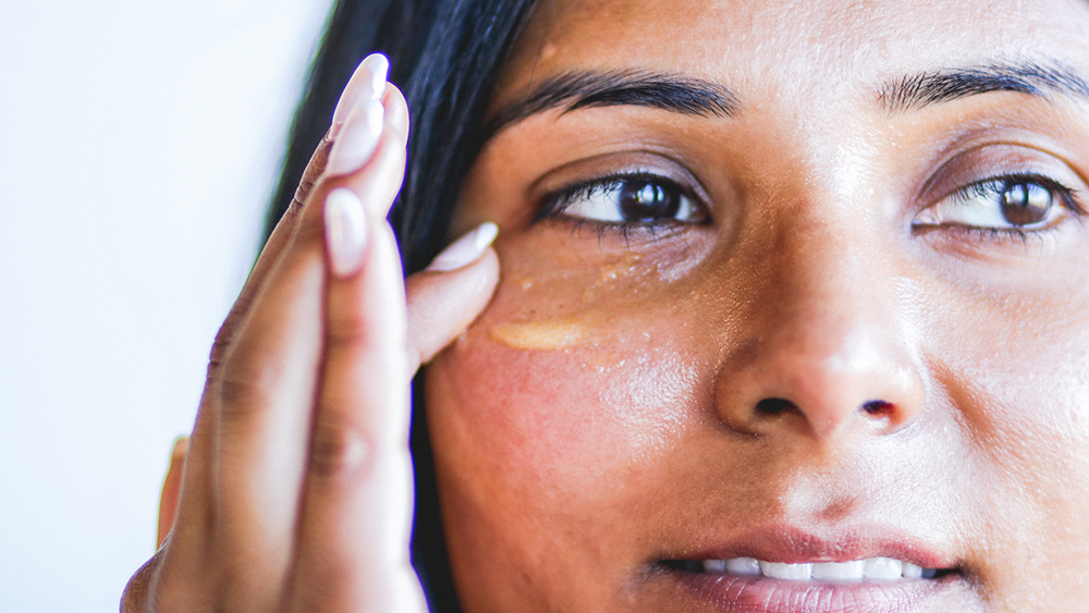 Woman applying niacinamide and vitamin c serum to face
