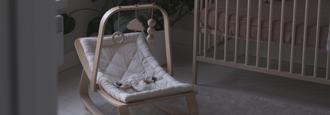 Charlie Crane LEVO rocker in Beech with Milk cushion and Beech Activity Arch in Nursery