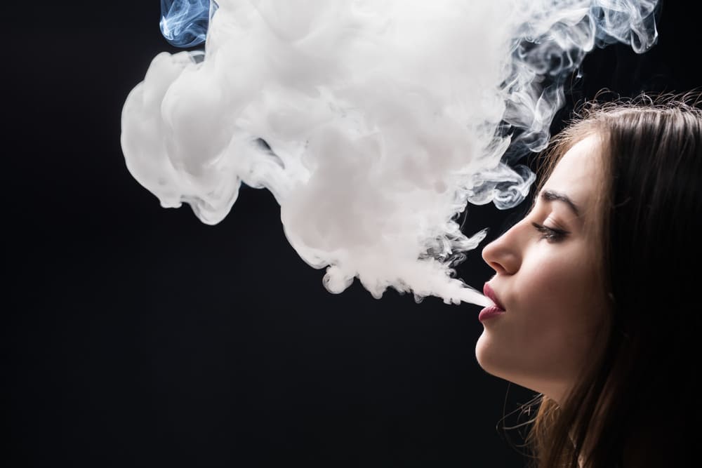 beautiful-woman-is-vaping-isolated-black-wall