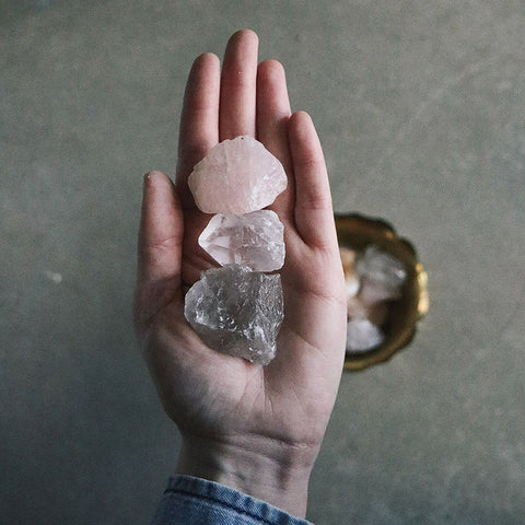Open hand holding three raw quartz crystals