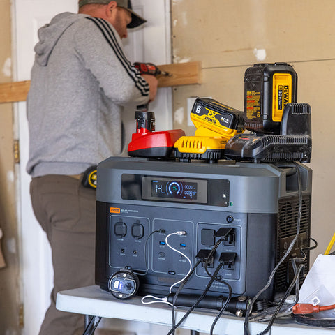 man drilling a door frame next to a solar generator