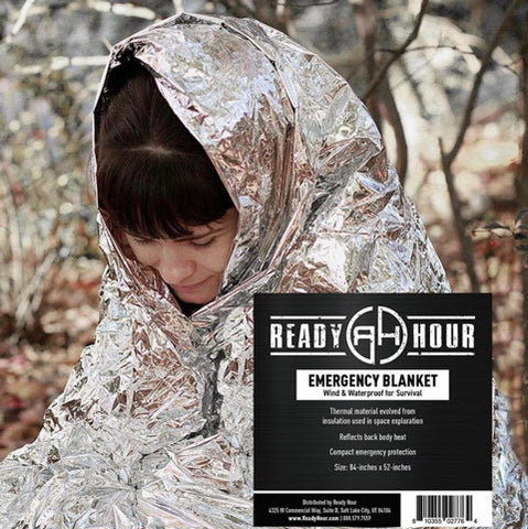 woman in a survival blanket in the woods
