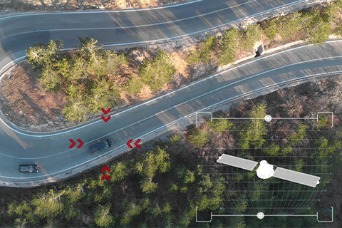 A winding road with cars driving along it, some red arrows pointed at the cars to indicate targets.