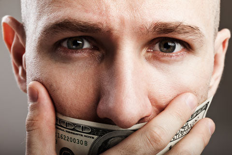 close up of a man hold a dollar bill over his mouth