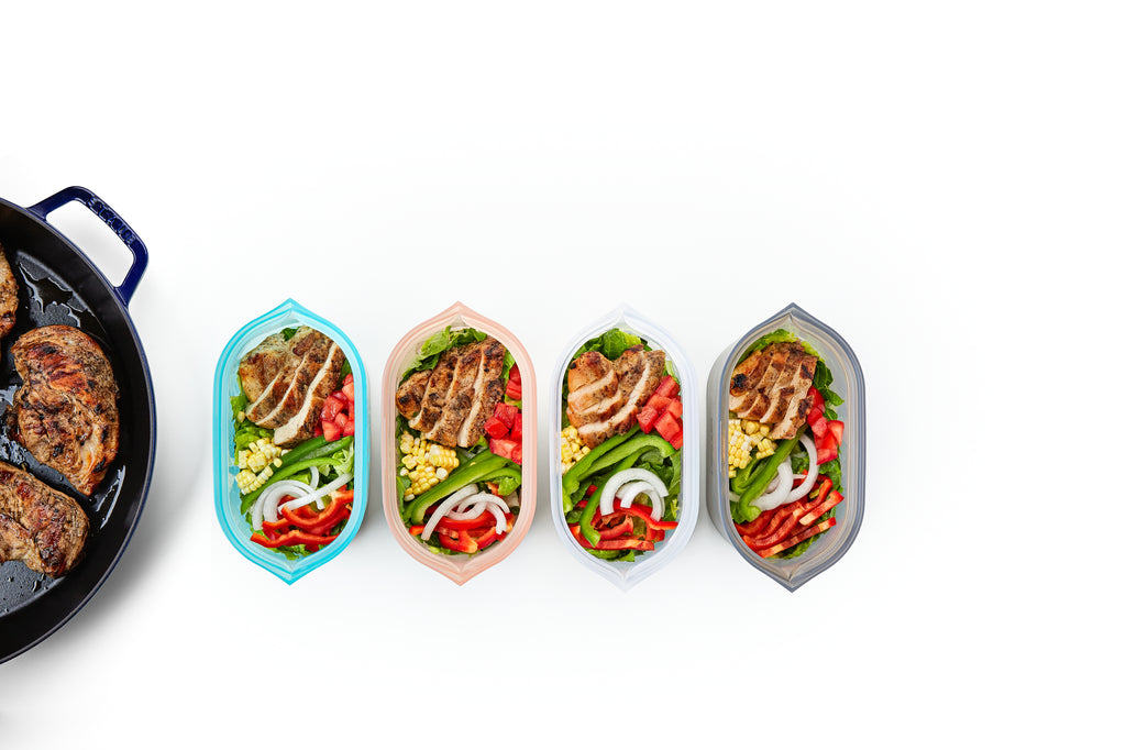 Reusable silicone dishes with fajita chicken salad on white smaller pan
