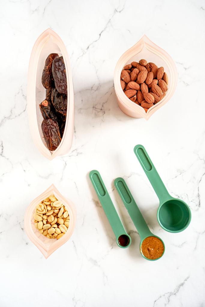 Reusable silicone containers overhead with vegan snickers ingredients