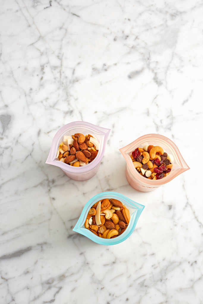 Small reusable silicone cups with trail mix on counter overhead 