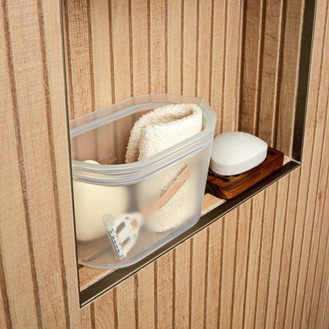 a bathroom shelf shows a frost Zip Top dish holding a razor, bar soap and a natural fiber washcloth