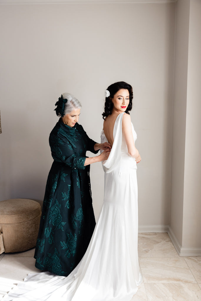 grandmother of the bride helping bride get dressed in old Hollywood glam dress