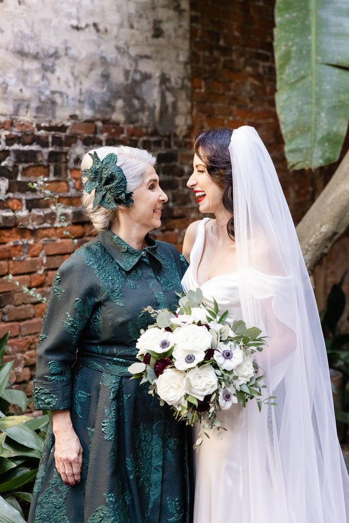 grandma of the bride in green long sleeve dress and bride in long silk wedding dress