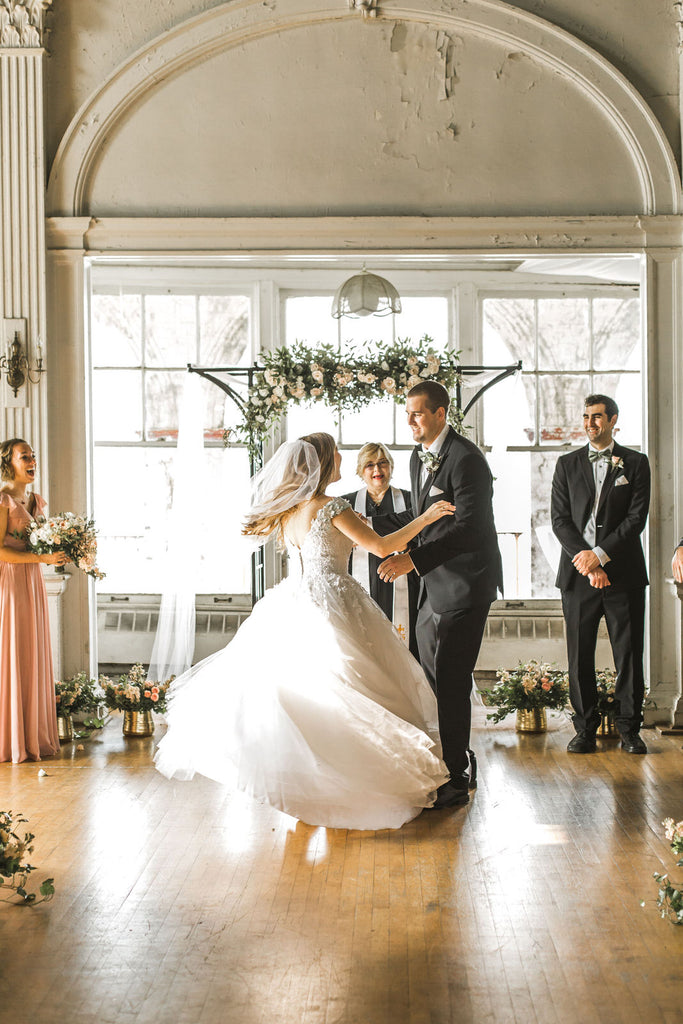 bride dancing in flowy gown and short raw edge veil
