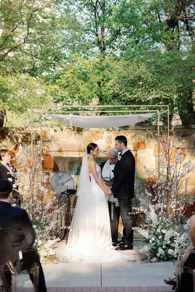 Jewish couple under chuppah with bride wearing drop silk wedding veil in white