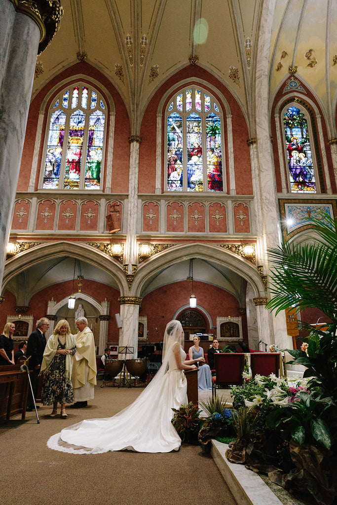 elegant church wedding with stain glass and bride in royal long cathedral wedding veil with corded eyelash lace trim in ivory
