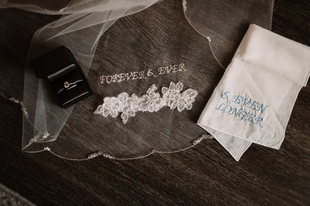 and even longer embroidered phrase veil with scallop edge and matching handkerchief with pale blue wording and engagement rings
