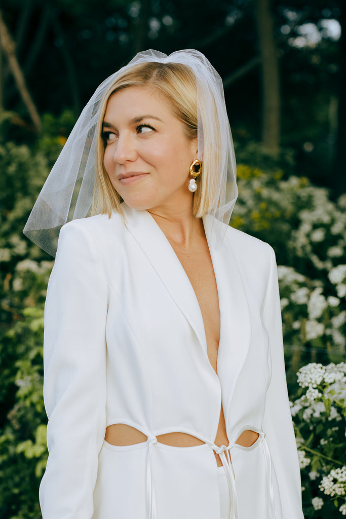 short bob hair with shoulder length wedding veil and bridal suit with waist cutouts