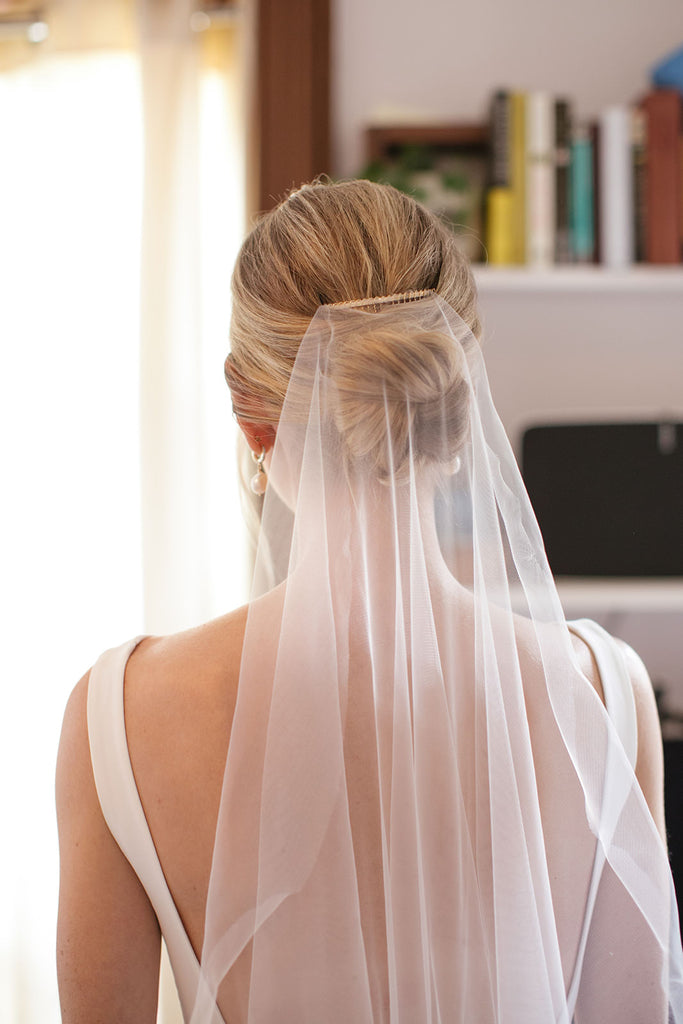 minimalist silk bridal veil with gold comb over low updo