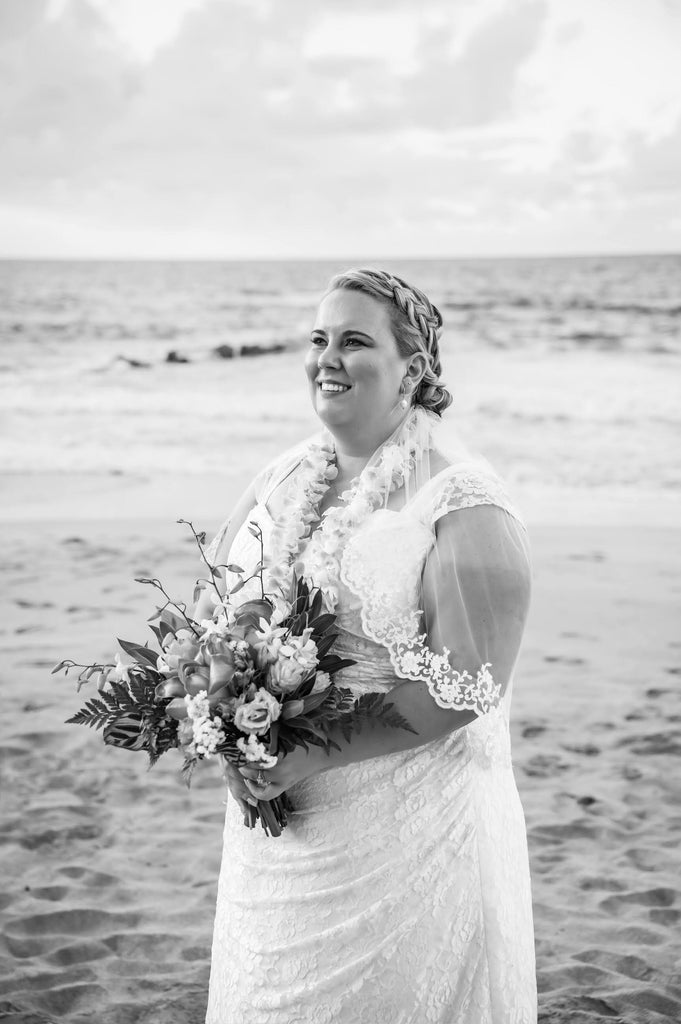 elbow length French lace veil for tropical wedding on bride at the beach holding bouquet