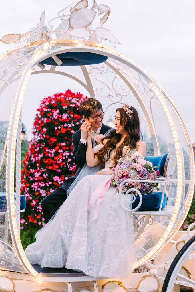 horse drawn carriage wedding at Disney with bride in long veil and gold sparkly tiara