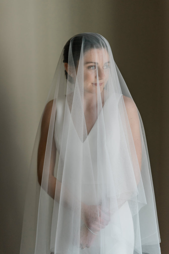 tight sleep bridal bun updo with drop blusher wedding veil