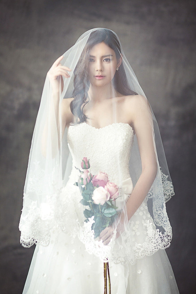 drop two layer lace wedding veil over bouquet in bride's hands