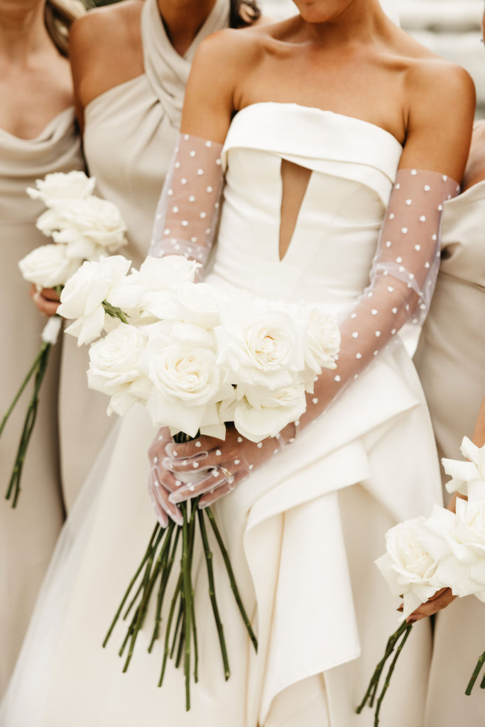 strapless bridal gown and heart embroidered glove set on bride holding white bouquet