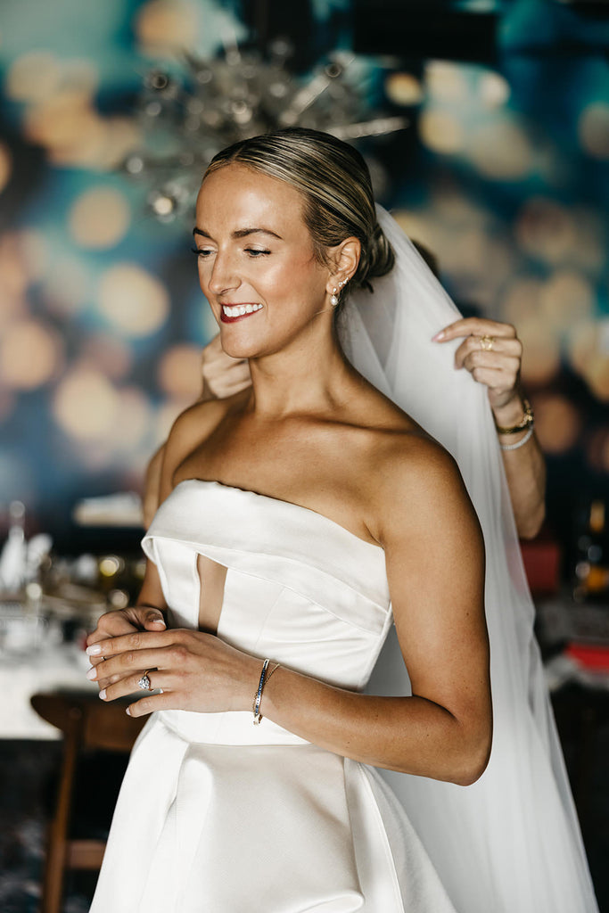 simple clean bridal updo bun with white veil and strapless mikado a line dress