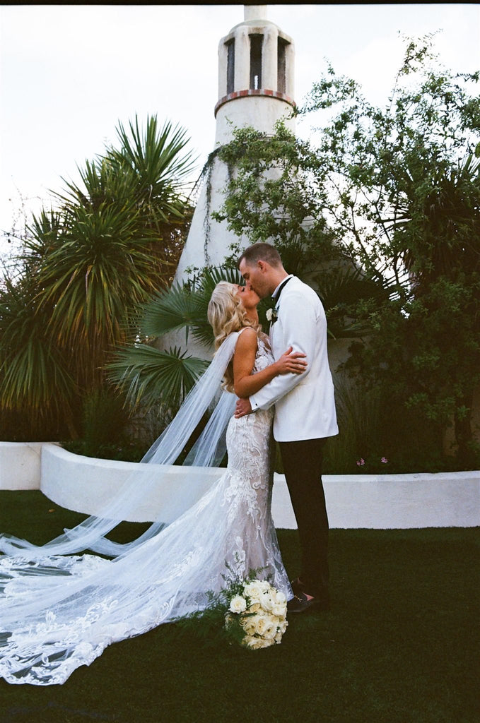 mission wedding with bride in lace gown with bridal cape veil wings on shoulders