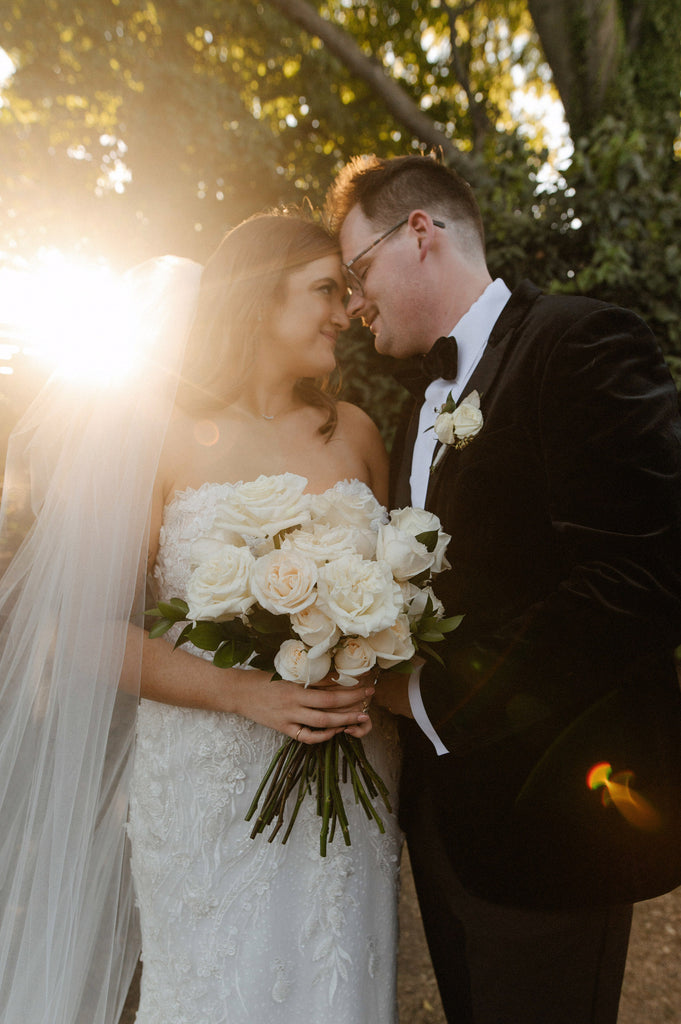 sunset wedding portraits with bride in full long cathedral veil with raw edge and holding white bouquet