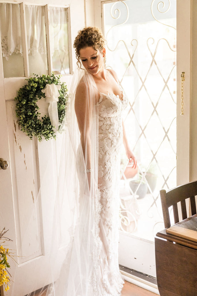 long lace chapel length bridal veil on bride with curly updo in California home wedding