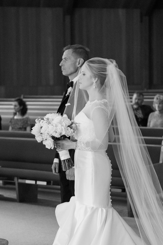 bride walking down aisle with Dad wearing blusher over face