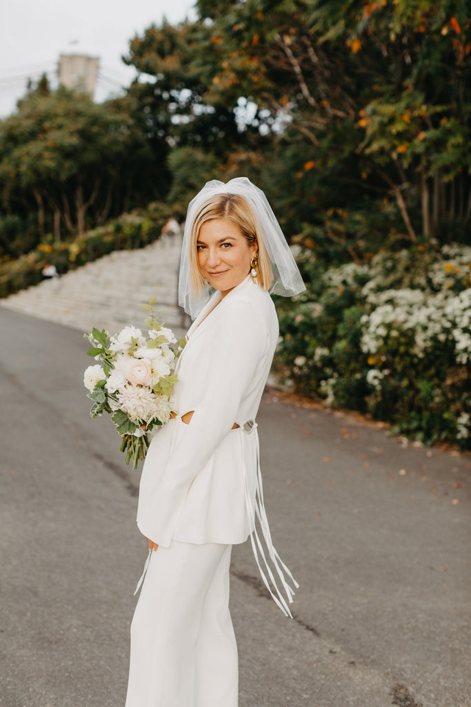 alternative bridal suit in white with short birdcage blusher veil