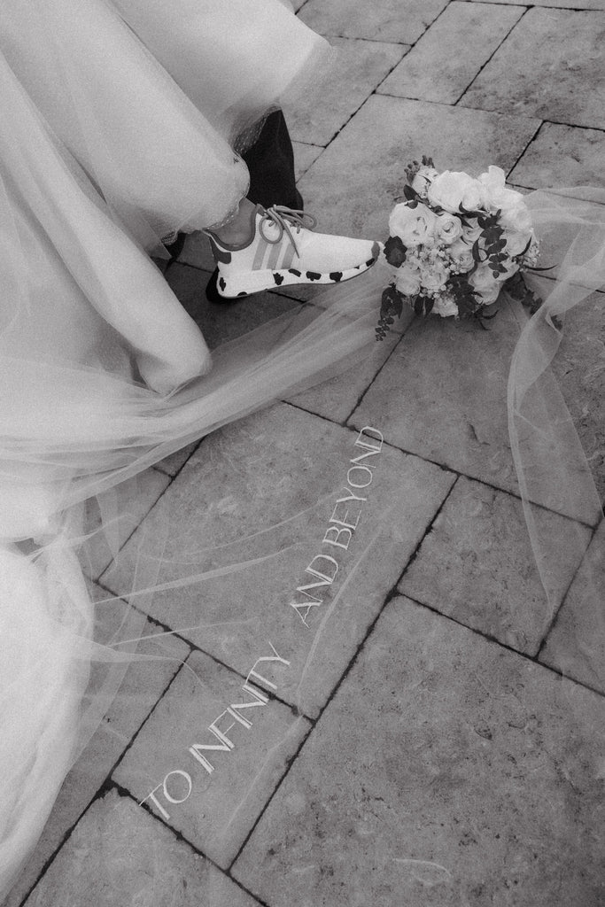 embroidered long wedding veil with custom font on bottom and bride in tennis shoes