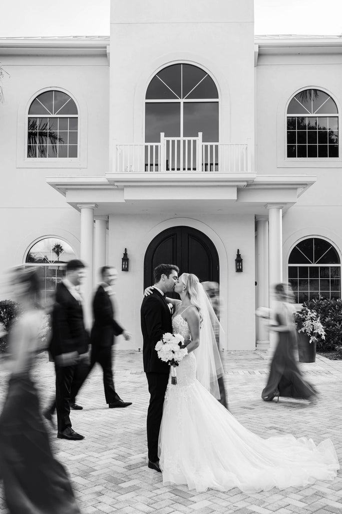 estate wedding with bride and groom embracing with knee length wedding veil in bride's downdo