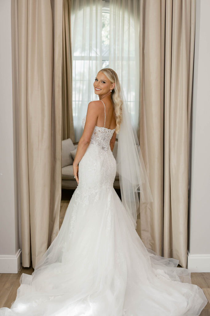 knee length waltz bridal veil in ivory glimmer with trumpet strapless bridal gown on bride with curled downdo hairstyle