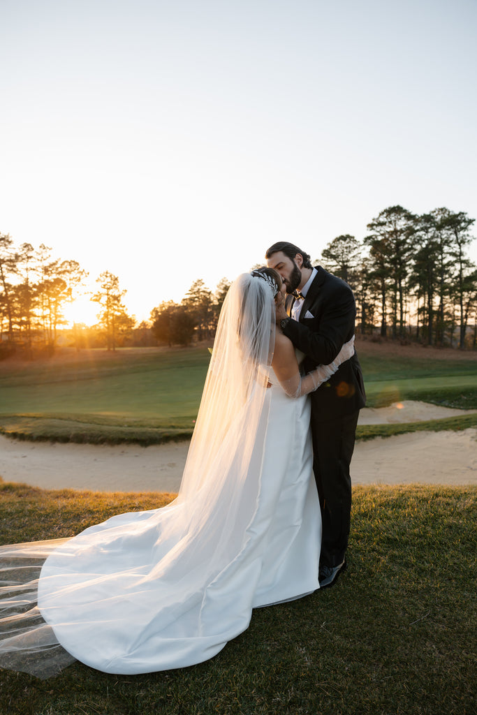 golf course wedding with ballgown and long bridal cathedral length bridal veil and beaded hairpiece in curled downdo