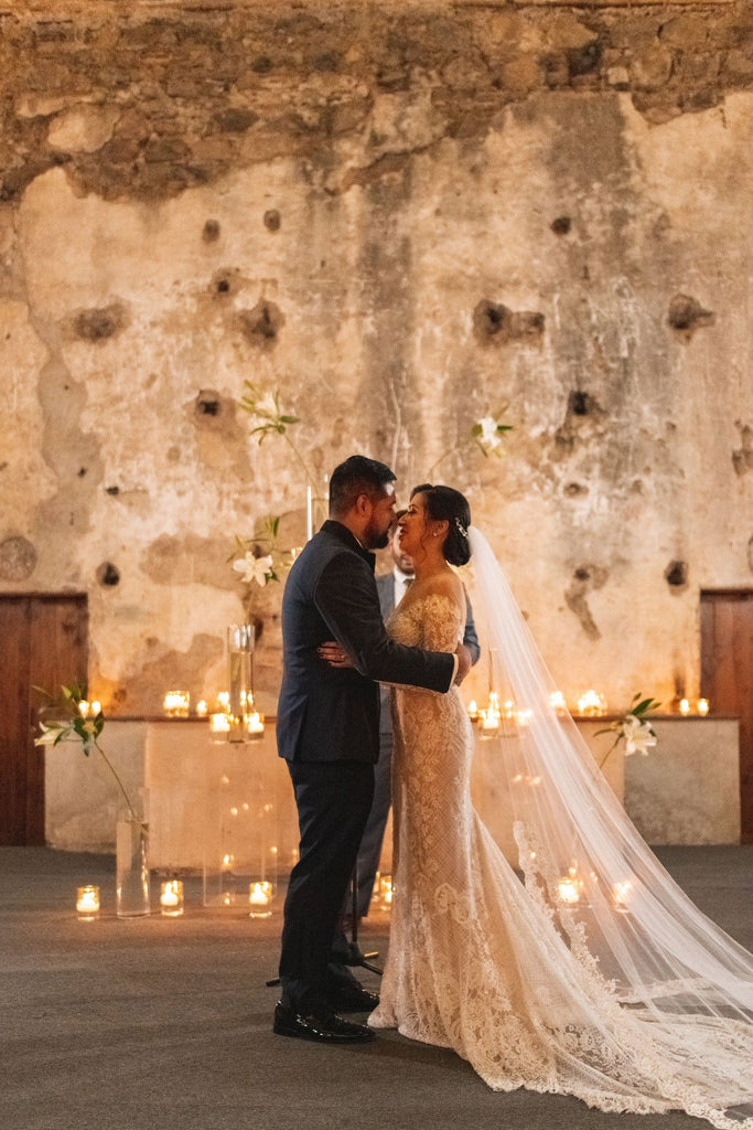 romantic spanish wedding decor with candles and bride in long cathedral lace bridal veil in ivory